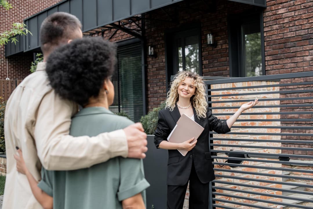 Consulente immobiliare che mostra una casa in vendita a una coppia